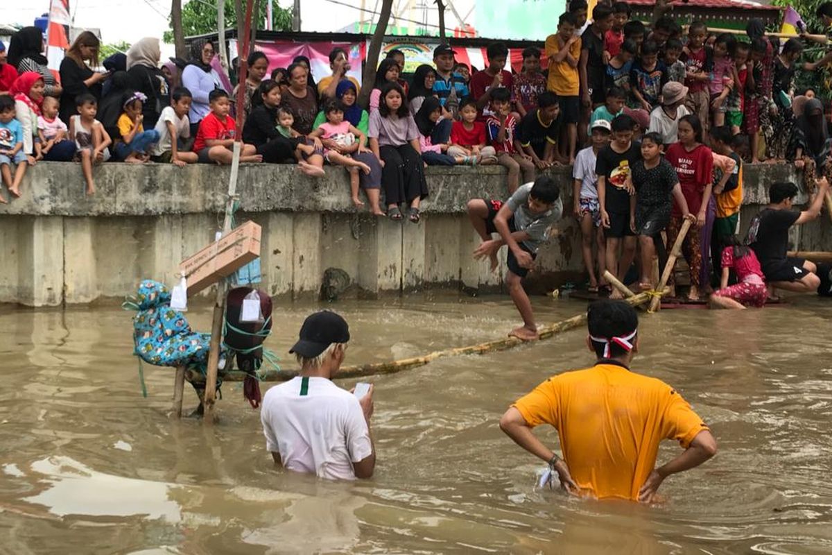 Keseruan warga yang ikut dalam lomba perayaan Hari Ulang Tahun Republik Indonesia ke 77 di aliran Kali Baru Pangeran Jayakarta, Rabu (17/8/2022). Sejumlah perlombaan mulai dari berjalan di atas bambu, gebuk bantal, hingga panjat pinang turut diperlombakan.