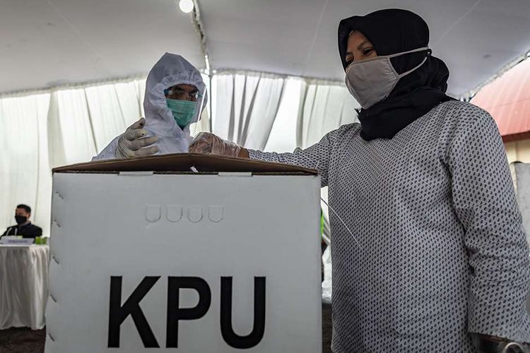 Foto dirilis Minggu (6/12/2020), memperlihatkan petugas KPPS mengenakan alat pelindung diri (APD) mendampingi warga memasukkan surat suara ke dalam kotak suara saat Simulasi Pemungutan dan Penghitungan Suara Pemilihan Bupati dan Wakil Bupati Semarang 2020 di Bergas, Kabupaten Semarang, Jawa Tengah.