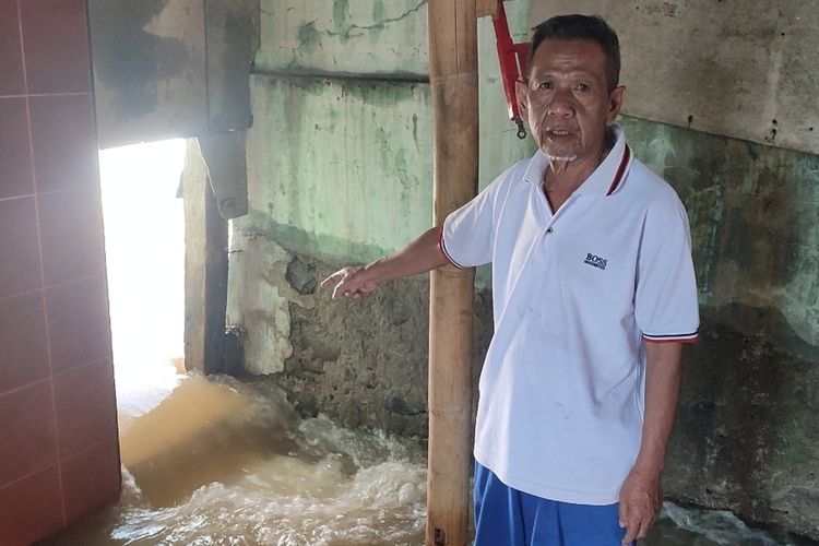 Edi Suhardi (65) warga satu dari tiga pemilik rumah yang jadi korban hantaman longsor gunung Bayu di Desa Citikur Kecamatan Ciwaru Kabupaten Kuningan, Minggu petang (2/4/2023). Rumah Edi kini menjadi jalan aliran air sungai cinondang yang tersumbat material longsor.