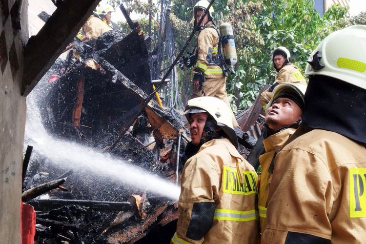 Petugas pemadam kebakaran sedang memadamkan sisa bara api yang melahap lima rumah di Gambir, Jakarta Pusat, Rabu (8/2/2023).