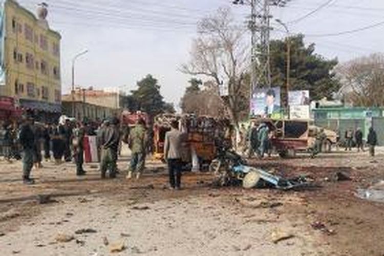 Warga kota Maimanah, provinsi Faryab, Afganistan menyaksikan sisa-sisa aksi bom bunuh diri yang terjadi di pusat kota itu, Selasa (18/3/2014), yang menewaskan sedikitnya 16 orang.