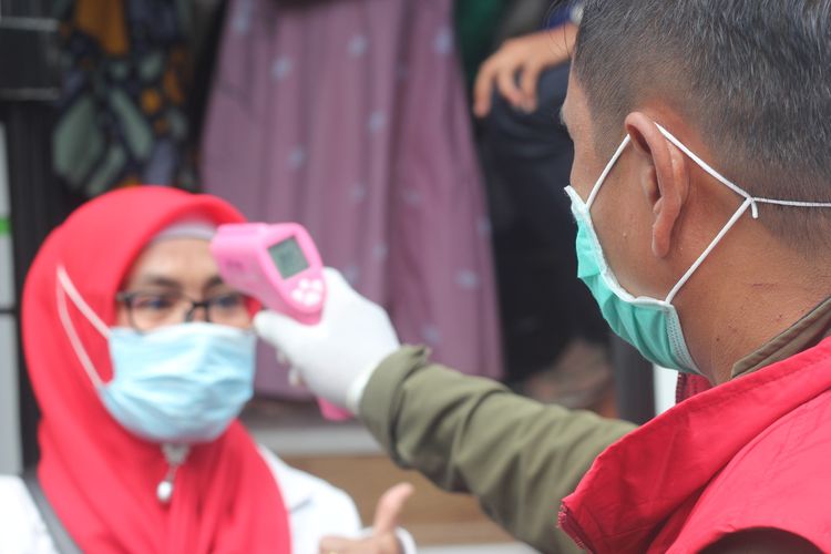 Seorang pengunjung kawasan Puncak saat diperiksa suhu tubuhnya oleh Satgas Covid-19 di check point Seger Alam Puncak Pass, Cianjur, Jawa Barat, Kamis (29/10/2020).