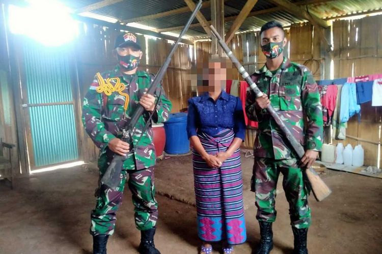 Ibu Y asal Eban, Kecamatan Miomafo Barat, Kabupaten Timor Tengah Utara, Nusa Tenggara Timur, saat menyerahkan dua pucuk senjata api laras panjang ke pasukan TNI dari Satgas Pamtas Indonesia-Timor Leste Sektor Barat Yonarmed 6/3 Kostrad, Kamis (20/5/2021)