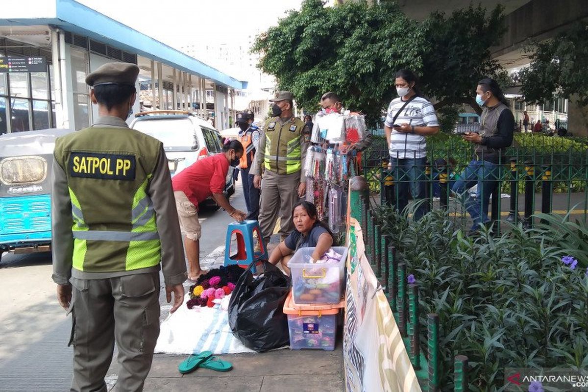 Petugas Satpol PP Jakarta Pusat menertibkan pedagang bandel di trotoar seberang Stasiun Tanah Abang, Senin (10/5/2021). 