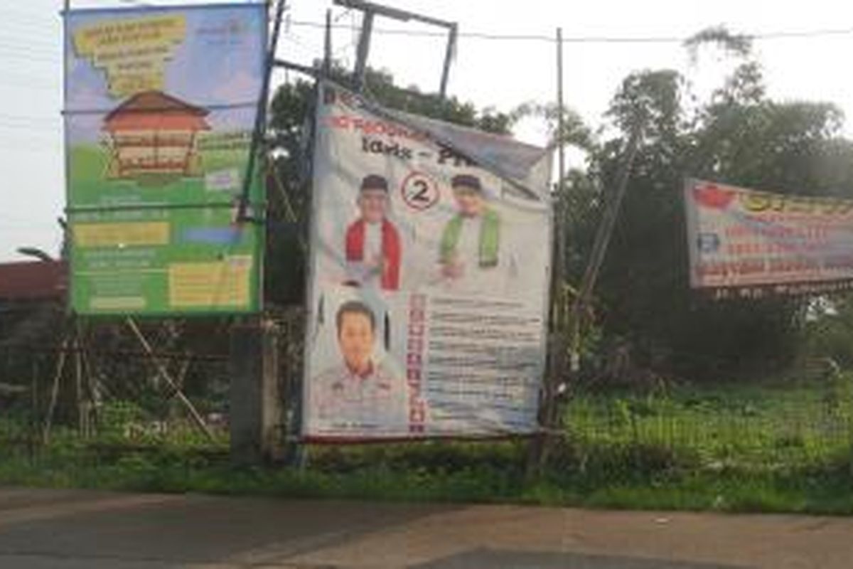 Baliho bergambar pasangan calon wali kota dan wakil wali kota Depok nomor urut dua, Idris Abdul Shomad dan Pradi Supriyatna yang masih terpasang di salah satu tiang listrik di Jalan Raden Saleh, Depok, di hari pertama masa tenang, Minggu (6/12/2015).