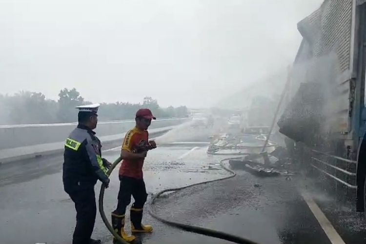 Petugas memadamkan api kebakaran mobil ekspedisi di jalan tol Pekanbaru-Dumai, Sabtu (4/11/2023).