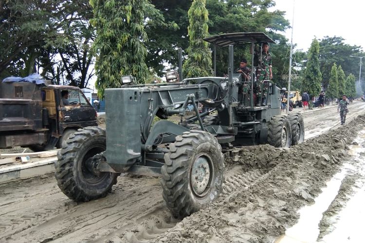 Alat berat yang digunakan untuk membersihkan material banjir bandang yang menutupi ruas Jalan Kemiri, Sentani, Senin (18/3/2019)