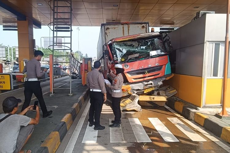 Petugas kepolisian sedang mengevakuasi truk fuso yang mengalami kecelakaan di Gerbang Tol Ciawi 2, Kota Bogor, Jawa Barat, Senin (2/6/2025).