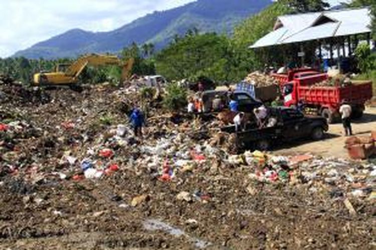 Sejumlah kenderaan dump truk sedang menurunkan muatan sampah yang diangkut dari wilayah yang terkena banjir bandang di Manado.