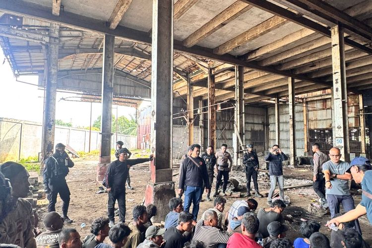  Polisi saat menangkap warga yang terlibat penjarahan besi pabrik PT ARB di Jalan Yos Sudarso, Kota Medan, Minggu (20/6/2025)