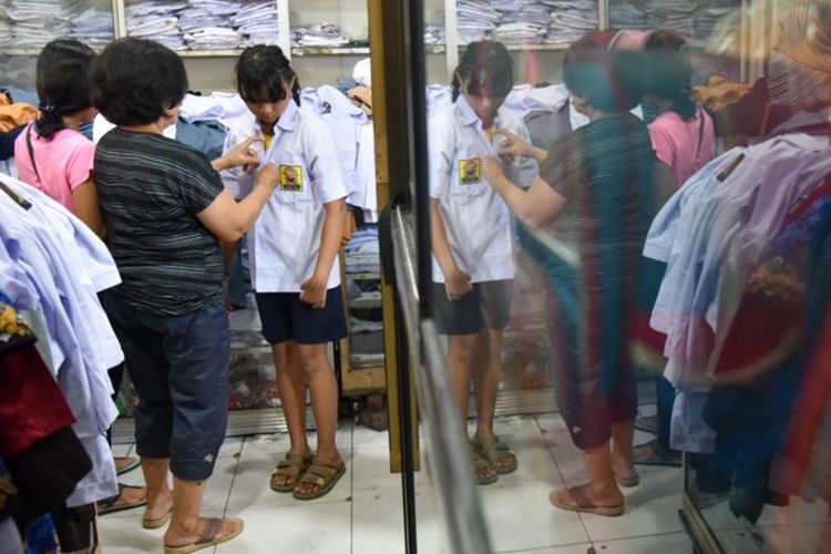 Foto ilustrasi. Seorang siswa mencoba seragam sekolah yang dijual di Pasar Pringgan, Medan, Sumatera Utara, Jumat (14/7).