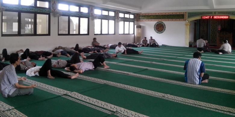 Usai melaksanakan salat zuhur, para pegawai tidur-tiduran di dalam masjid.