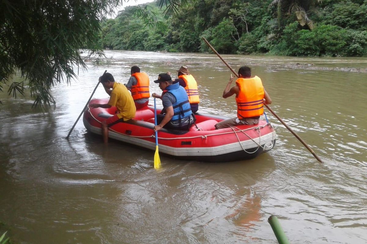 Pencarian korban yang hanyut saat melintas di jembatan Jujuan, Solok Selatan dilakukan dengan menggunakan perahu karet, Minggu (8/12/2019)