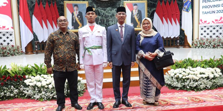 Penjabat (Pj.) Gubernur DKI Jakarta berfoto bersama salah satu anggota Pasukan Pengibar Bendera Pusaka Tingkat Provinsi DKI Jakarta Tahun 2024, Adya, dan kedua orangtuanya, usai acara Pengukuhan Paskibraka DKI Jakarta di Balaikota, Jakarta Pusat, Rabu (14/8/2024).