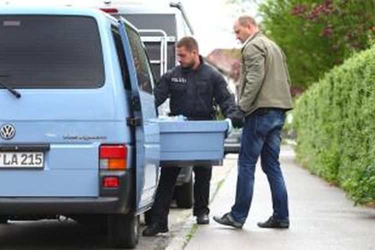 Seorang polisi Jerman memasukkan sekotak barang bukti yang disita di sebuah apartemen di kota Augsburg ke dalam mobil, Pada Rabu (6/5/2015), kepolisian melakukan penggerebekan di lima negara bagian dan berhasil menangkap empat tersangka yang berencana melakukan serangan teror terhadap warga Muslim.