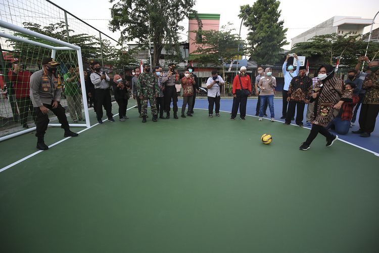Wali Kota Surabaya Tri Rismaharini menendang bola saat meresmikan lapangan olahraga Tambak Asri, Surabaya, Minggu (16/8/2020).
