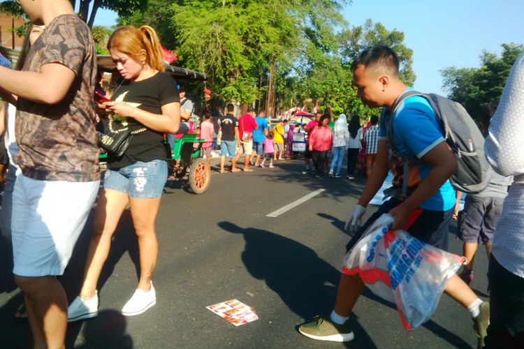 Anggota Komunitas Pelangi Samudera sedang mengambil sampah dalam gerakan kampanye pungut sampah di arena car free day (CFD) Solo, Jawa Tengah, Minggu (19/8/2018).