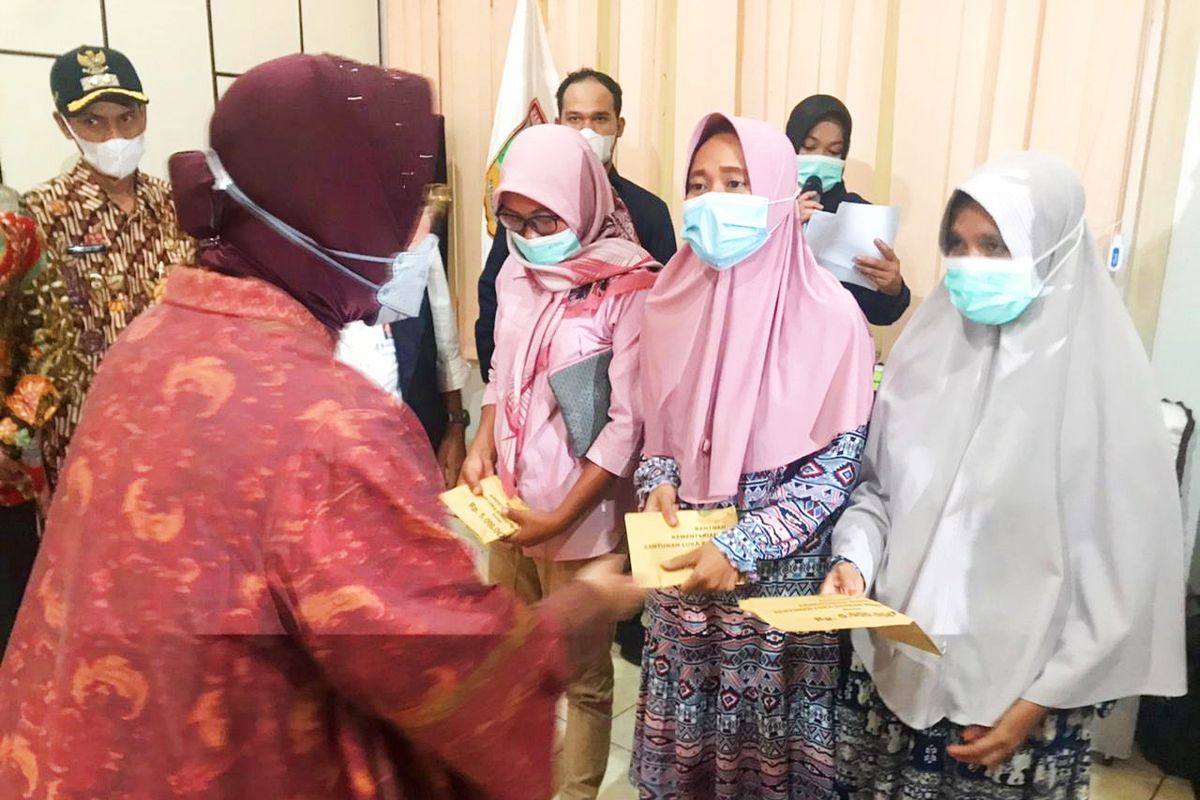 Menteri Sosial (Mensos) Tri Rismaharini saat menyerahkan bantuan sosial kepada para korban bencana longsor di Kabupaten Solok, Sumatera Barat, pada Rabu (12/5/2021).