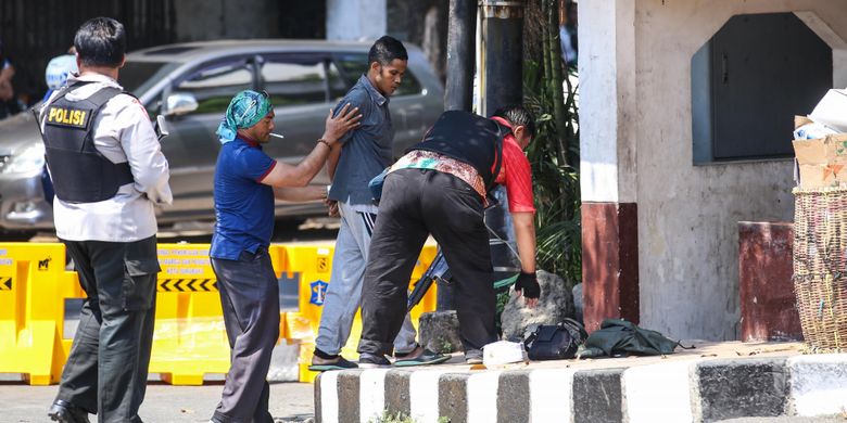 Polisi memeriksa seorang yang dicurigai membawa tas berisi bom di kawasan Mapolrestabes Surabaya, Jawa Timur, Senin (14/5/2018). sekitar pukul 08.50 WIB, menyebabkan 4 anggota polisi dan 6 warga terluka.