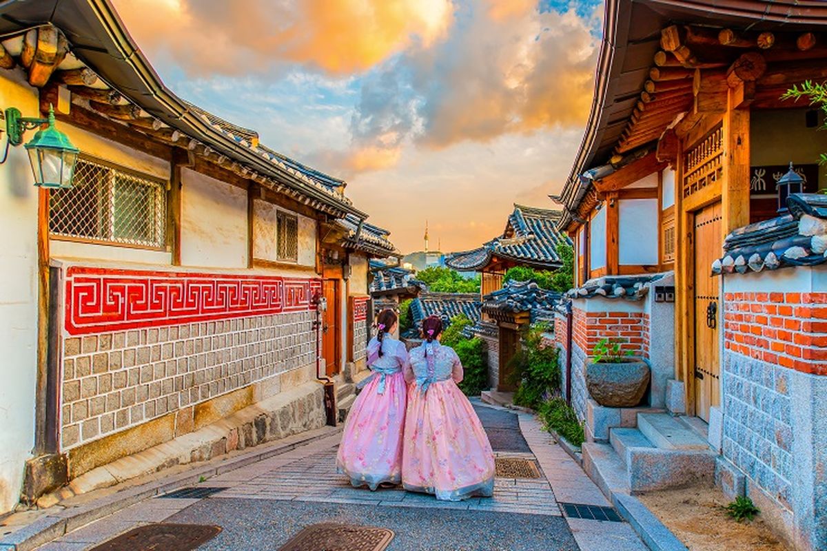 Ilustrasi Korea Selatan - Dua orang wisatawan sedang menggunakan hanbok dan berjalan-jalan di Bukchon Hanok Village, Korea Selatan.