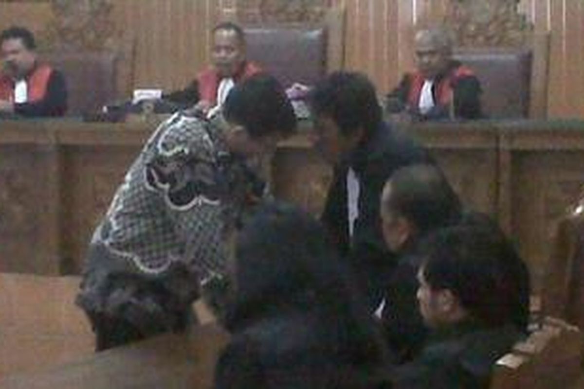 Sher Mohammad Febri Awan, terdakwa kasus pembunuhan Raafi Aga Winasya Benjamin, saat berdiskusi dengan penasihat hukumnya Aidy Johan dalam persidangan di Pengadilan Negeri Jakarta Selatan, Kamis (12/7/2012).