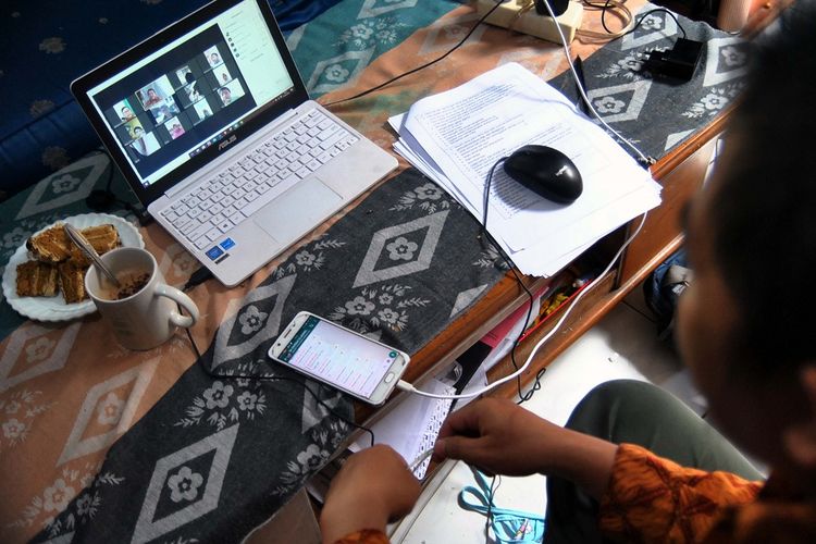 Guru SD berkomunikasi dengan siswa saat proses belajar mengajar (PBM) melalui aplikasi media daring dirumahnya di Kelurahan Bubulak, Kota Bogor, Jawa Barat, Rabu (1/4/2020). Dinas Pendidikan Jawa Barat menginformasikan pengawas dan pihak sekolah untuk melaksanakan PBM dari rumah fokus pada pendidikan dan kecakapan hidup antara lain mengenai pandemi virus Corona (COVID-19) serta melalui pembelajaran media daring dengan variasi sesuai peserta didik. ANTARA FOTO/Arif Firmansyah/foc.