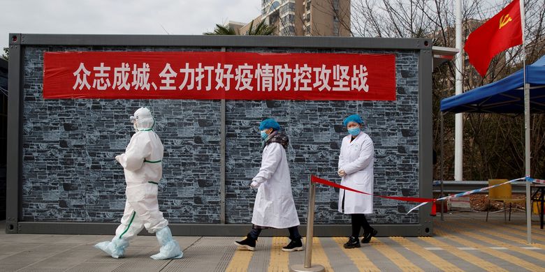 Staf medis dengan pakaian lengkap berjalan di pos pemeriksaan zona eksklusi Jembatan Sungai Yangtze di Jiujiang, Provinsi Hubei, pada 1 Februari 2020 di tengah merebaknya virus corona.