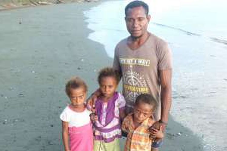 Yoram Ramawa bersama tiga anaknya di pantai Inggrisau, Kabupaten Kepulauan Yapen, Papua. 