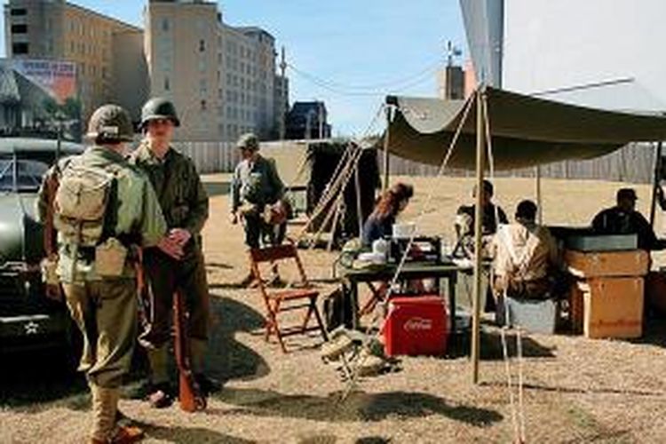 Komunitas reka ulang (reenactor) mengenakan seragam tentara AS dan Jerman lengkap dengan peralatan tempur bergaya di halaman museum.