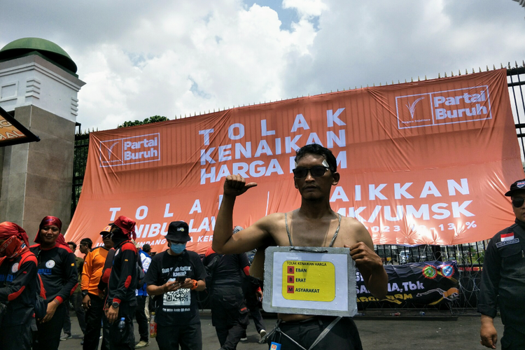 Seorang buruh mengenakan atribut bertuliskan tolak kenaikan BBM saat aksi demonstrasi di depan Gedung DPR/MPR RI, Jakarta Pusat, Selasa (6/9/2022).