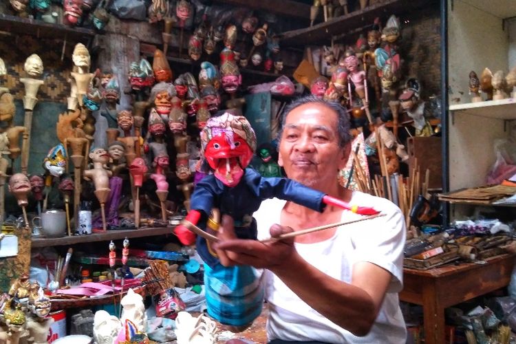Tatang Heryana (66) tengah memainkan wayang cepot di galerinya di Kampung Wayang Urban, Kota Bandung. 