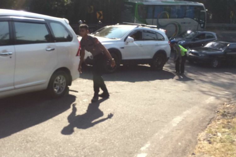 Polisi Ganjal Ban Bertugas di Tanjakan Slumprit, Patuk, Gunungkidul, membantu Kendaraan Yang terjebak Kemacetan arah Gunungkidul