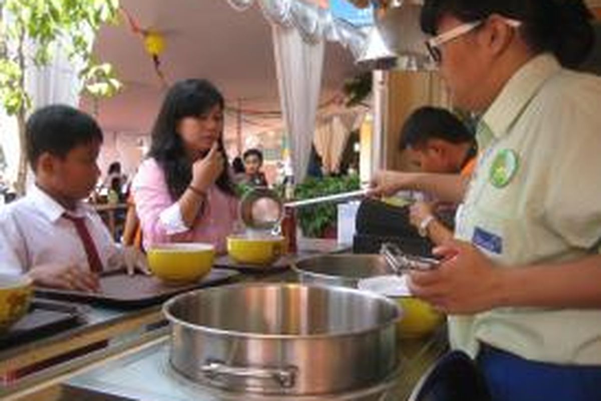 Siswi Sekolah Menengah Kejuruan (SMK) Strada Budi Luhur Kota Bekasi melayani konsumen di Laboratorium Kewirausahaan Bakso Sehat Bakso Atom (BSBA) di kompleks sekolah, Jalan Ir. H. Juanda 164, Bekasi pada Senin (26/8/2013).Gerai ini menjadi pelopor bagi  empat gerai berikutnya di seluruh SMK kejuruan ekonomi Perkumpulan Strada. 