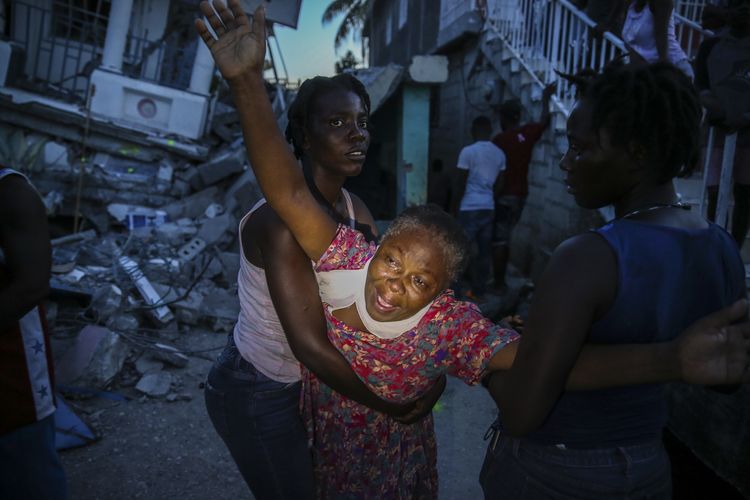 Axeline Morensi (tengah) menangis kencang saat jenazah putrinya Esther Daniel (7) ditarik keluar dari reruntuhan rumahnya di Les Case, Haiti, yang ambruk pada Sabtu (14/8/2021).  Survei Geologi AS (USGS) mengatakan gempa berkekuatan 7,2 itu berpusat di 125 kilometer barat ibu kota Port-au-Prince.