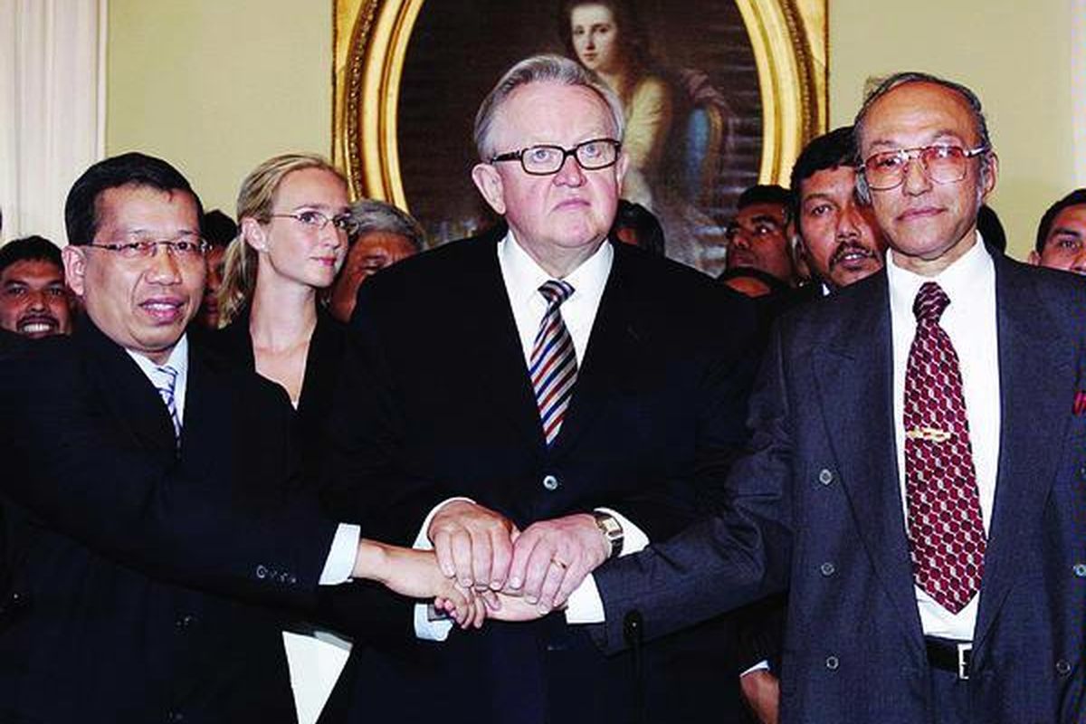 Ketua negosiator Indonesia, Hamid Awaluddin (kiri), berjabat tangan dengan mediator, Martti Ahtisaari (tengah), dan Malik Mahmud, wakil dari Gerakan Aceh Merdeka, setelah penandatanganan naskah perdamaian Aceh, di Helsinki, Finlandia, 15 Agustus 2005.