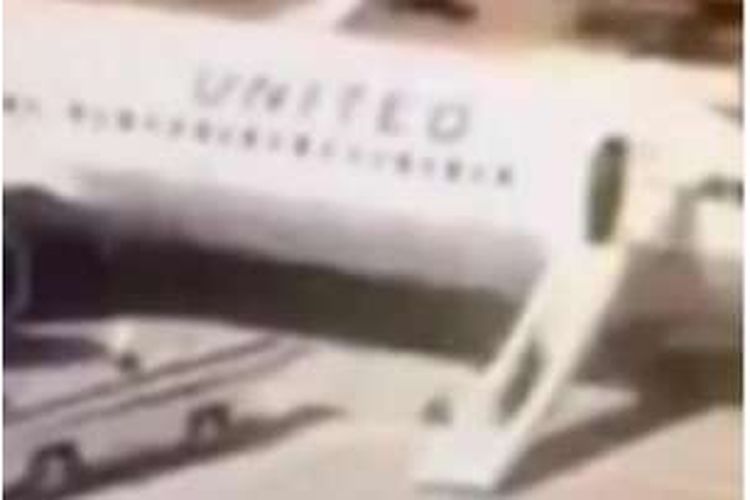Rekaman video menunjukkan seorang pramugari maskapai United Airlines keluar pesawat dengan cara yang tak biasa. 