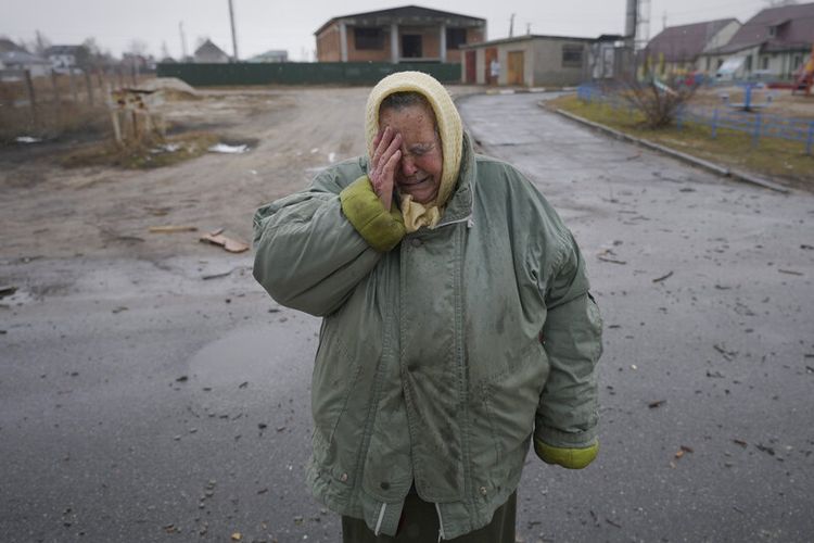 Seorang wanita menangis di luar rumah yang rusak akibat serangan udara Rusia, menurut penduduk setempat, di Gorenka, di luar ibu kota Keiv, Ukraina, Rabu, 2 Maret 2022.