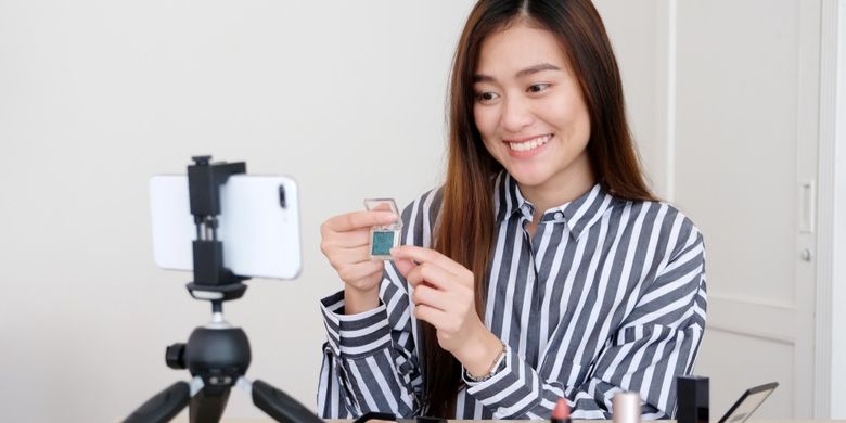 Ilustrasi beauty vlogger dengan menggunakan smartphone