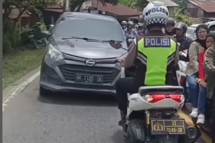 Tangkapan layar video viral polisi dengan mengendarai sepeda motor dinas memukul mundur pengemudi mobil yang ngeblong atau mengambil jalur saat jalan macet.