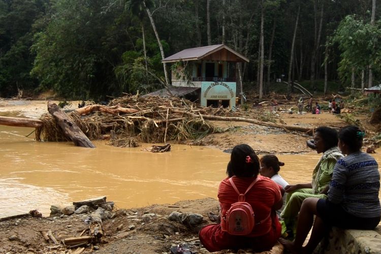 Sejumlah orang duduk di pinggir Sungai Landak Desa Sampe Raya Kecamatan Bahorok Langkat pada Rabu (18/11/2020) sore. Banjir bandang memporak-porandakan bangunan. Ditemukan kayu-kayu besar sepanjang 5 km.