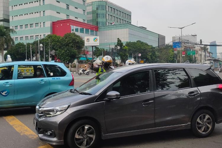 Polisi berhentikan kendaraan mobil akibat melanggar aturan ganjil genap setelah mulai diterapkan aturan sanksi tilang bagi para pelanggar di Jalan Balikpapan, Gambir, Jakarta Pusat, Selasa (14/6/2022).