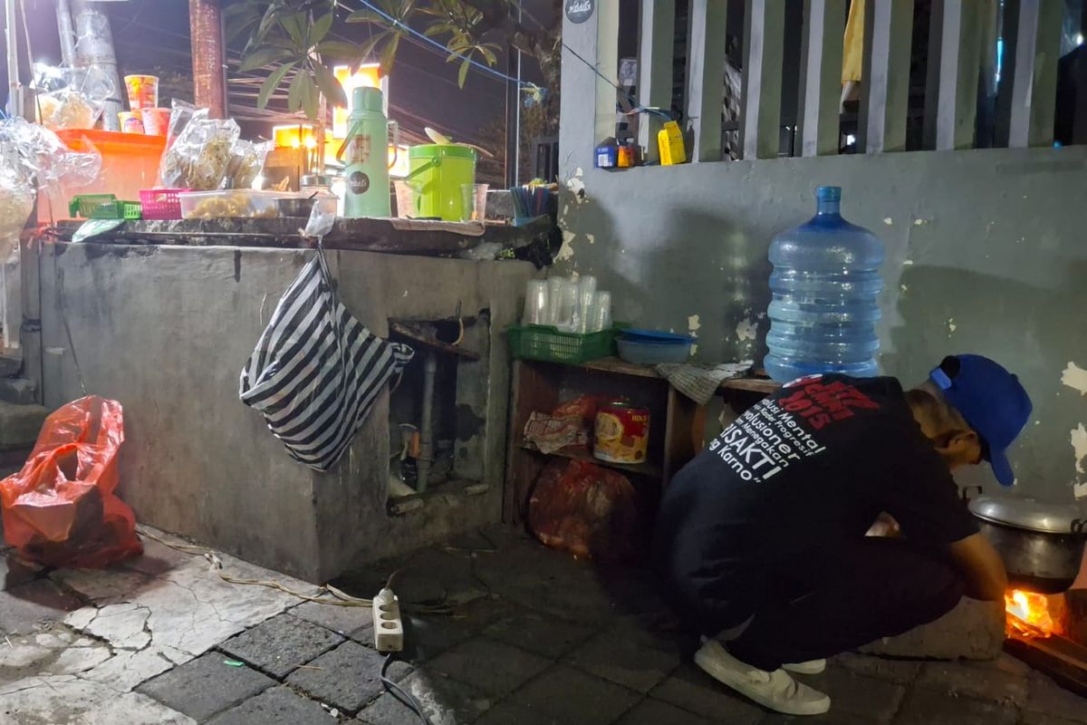 Rombli, (32), pedagang nasi jinggo, terpaksa memasak pakai tungku berbahan kayu bakar karena kesulitan mendapat gas elpiji 3 kilogram di Jalan Setia Budi, Kuta, Kabupaten Bandung, Bali, pada (3/2/2025). 