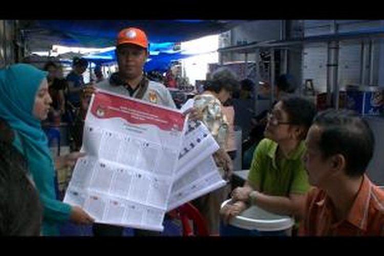 Relawan dari KIP sedang memberitahukan tata cara mencoblos ke warga keturunan Tionghoa di Aceh.