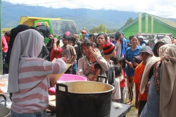 Warga antre mendapat bantuan makanan di posko pengungsian yang tersebar di Wamena. 