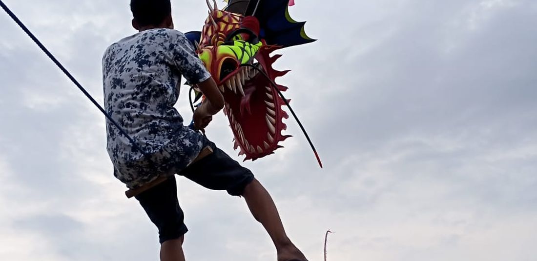 Wisata alternatif di Bantul - Seorang wisatawan sedang menaiki layangan naga raksasa di Kabupaten Bantul, Yogyakarta.