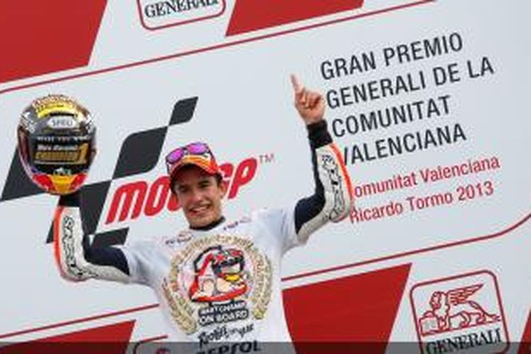 Pebalap Repsol Honda asal Spanyol, Marc Marquez merayakan suksesnya menjadi Juara Dunia MotoGP 2013, setelah finis ketiga pada GP Valencia, November 2013.