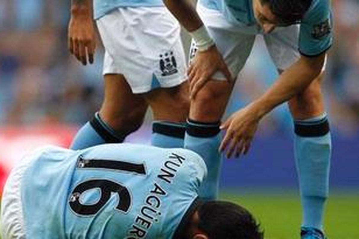 Gelandang Manchester City dari Perancis, Samir Nasri (kanan), menanyai keadaan rekan seklubnya dari Argentina, penyerang Sergio Aguero, yang terkapar setelah cedera ditekel pemain Southampton, Nathaniel Clyne, dalam laga perdana Premier League 2012/13 di Stadion Etihad, Manchester, Minggu (19/8/2012). 