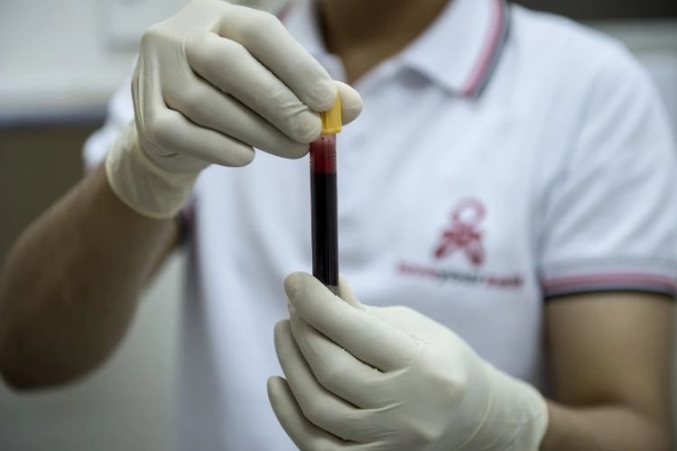 Seorang perawat memegang botol darah di pusat pengujian di Manila.