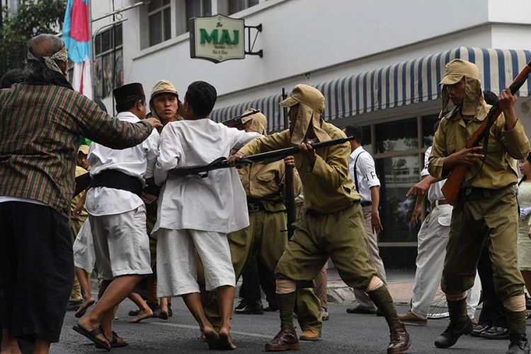 Warga terlibat saling dorong dengan pasukan Jepang di depan Hotel Majapahit saat teatrikal peristiwa perobekan bendera di Hotel Yamato (kini Hotel Majapahit) di Jalan Tunjungan, Surabaya, Jawa Timur, Rabu (19/9/2018). Kegiatan tersebut dalam rangka memperingati peristiwa perobekan bendera Belanda menjadi bendera Indonesia pada 19 September 1945.