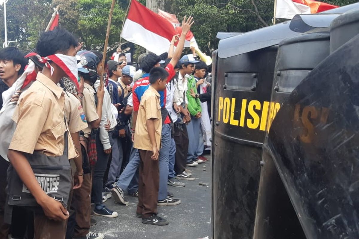 Ratusan pelajar dengan seragam pramuka, SMK, dan STM menyerang aparat kepolisian dari brimob yang sedang bertugas menjaga pintu belakang Gedung DPR/MPR RI, Jakarta Pusat. Pantuan Kompas.com pada Rabu (25/9/2019) siang, sekitar pukul 14.00 WIB, massa dari kalangan pelajar sempat melempari batu ke arah aparat yang sedang bertugas.